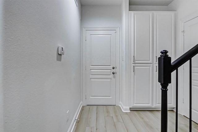doorway to outside with baseboards and light wood-style floors