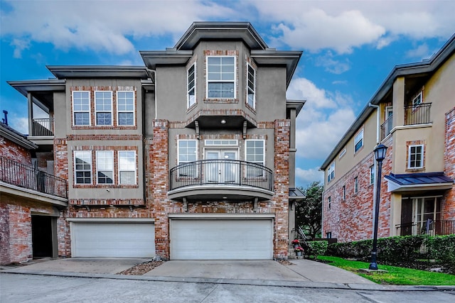 townhome / multi-family property with brick siding, driveway, and an attached garage