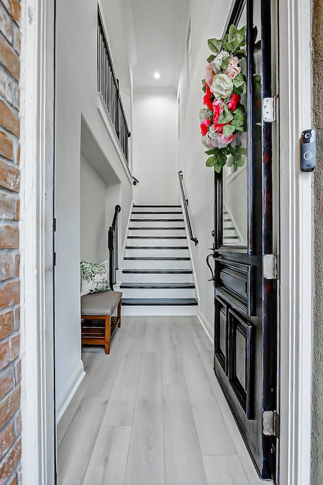 foyer featuring recessed lighting, stairway, wood finished floors, and baseboards