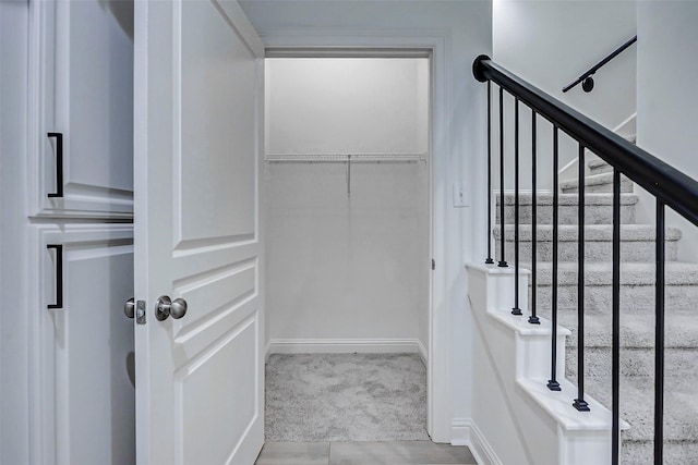 stairway with baseboards and carpet flooring