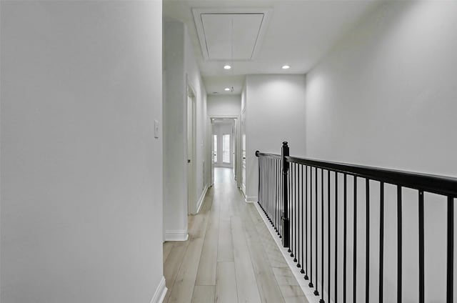 hallway with baseboards, recessed lighting, attic access, and light wood-style floors
