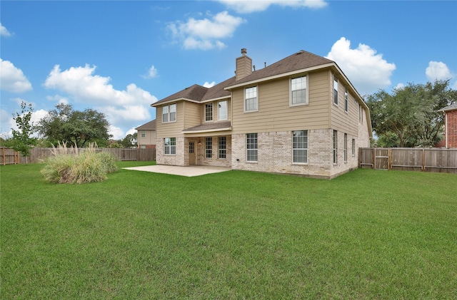 back of property with a patio, a chimney, a fenced backyard, and brick siding