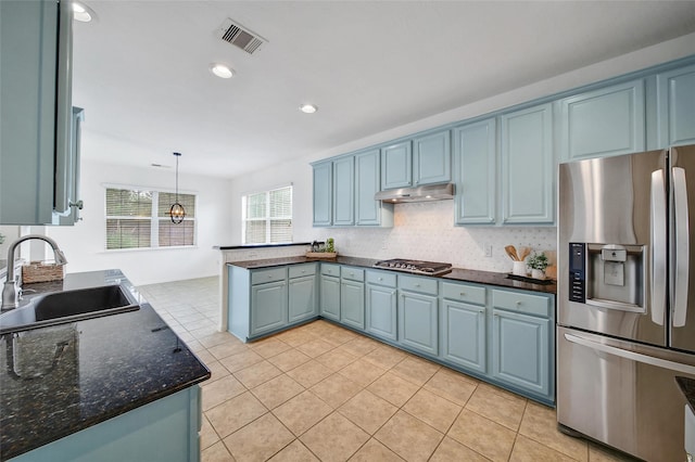 kitchen featuring stainless steel appliances, under cabinet range hood, a sink, visible vents, and a peninsula