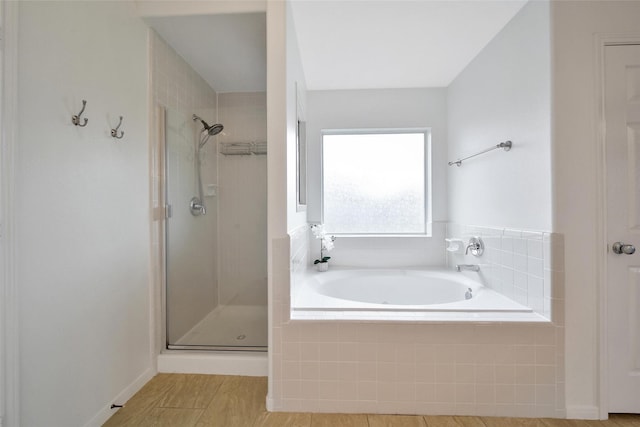 full bathroom with a shower stall and a bath