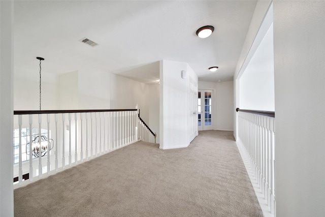 hall featuring visible vents and carpet floors