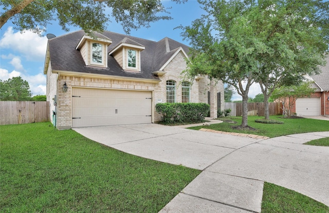 view of front of property with brick siding, fence, a front yard, and concrete driveway