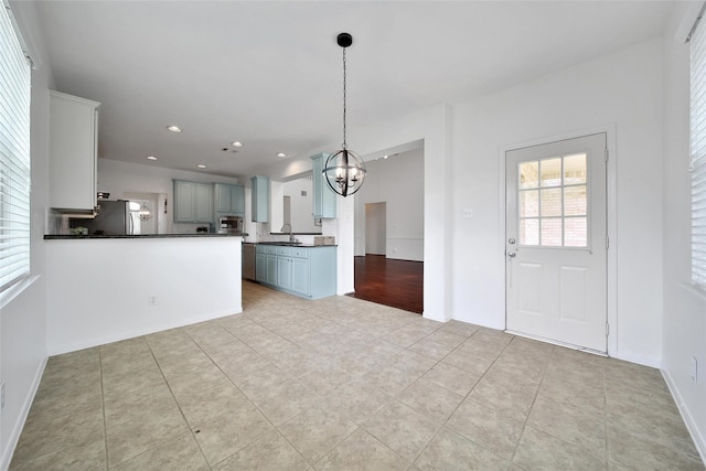 kitchen featuring recessed lighting, a chandelier, light tile patterned floors, stainless steel appliances, and dark countertops