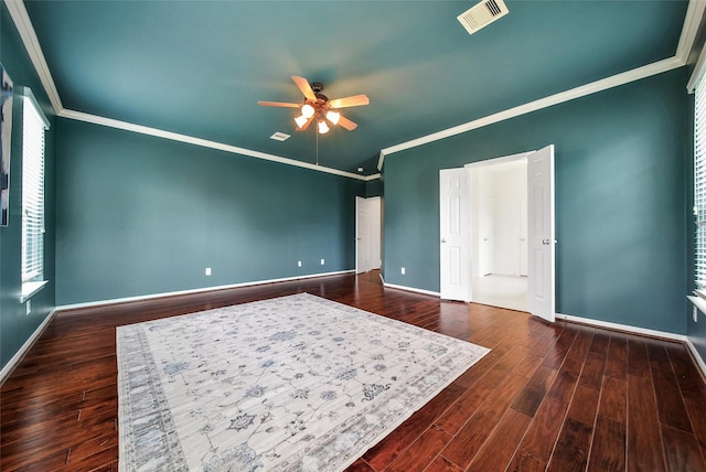 bedroom with baseboards, visible vents, wood finished floors, and crown molding