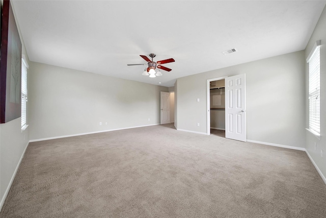 unfurnished bedroom with baseboards, visible vents, carpet floors, and multiple windows