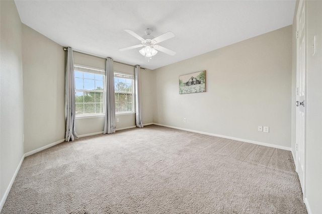 carpeted empty room with ceiling fan and baseboards