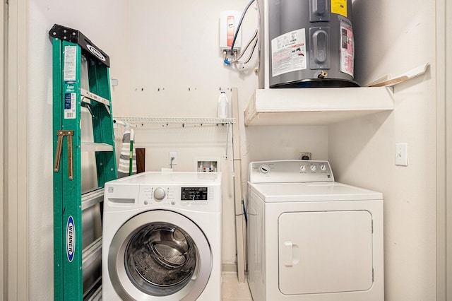 clothes washing area featuring washer and dryer, laundry area, and electric water heater