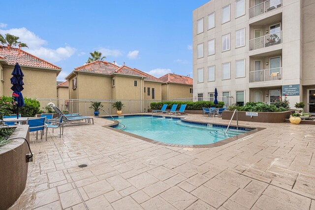 pool with fence and a patio