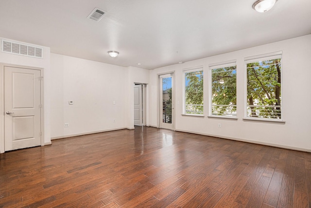spare room with visible vents, wood finished floors, and baseboards