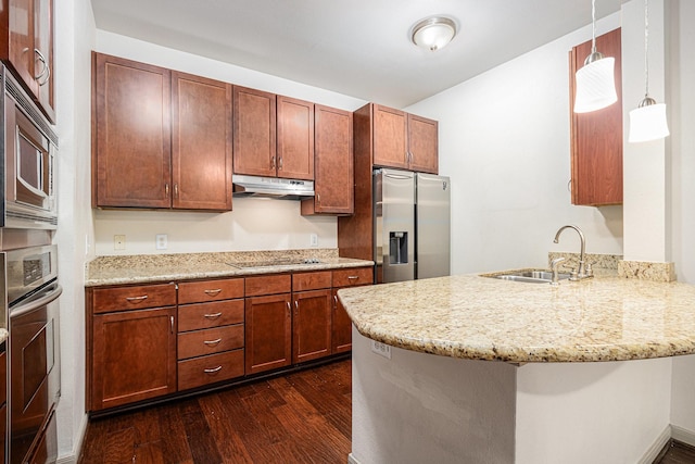 kitchen with a sink, under cabinet range hood, dark wood-type flooring, a peninsula, and appliances with stainless steel finishes