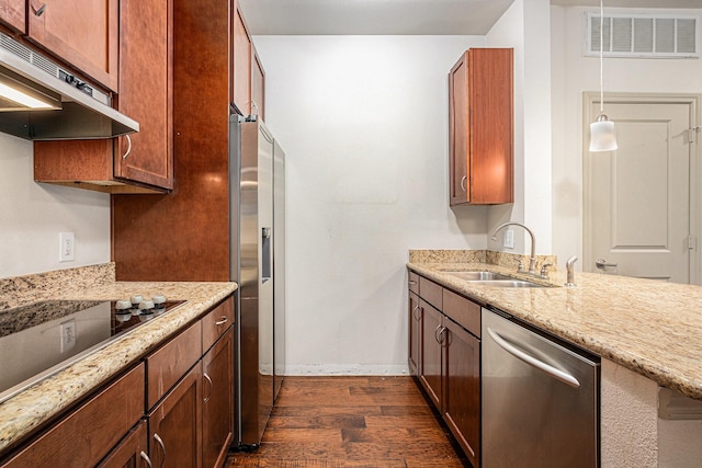 kitchen featuring dark wood finished floors, under cabinet range hood, appliances with stainless steel finishes, a sink, and visible vents