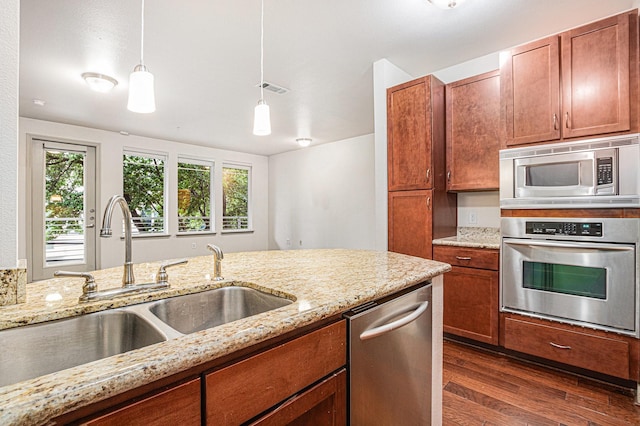 kitchen with a sink, visible vents, stainless steel appliances, dark wood-style flooring, and decorative light fixtures