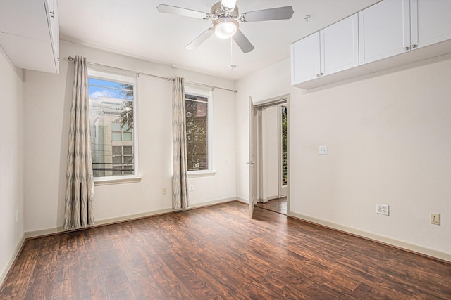 spare room with a ceiling fan, wood finished floors, and baseboards