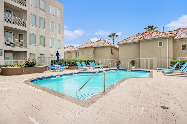 pool with fence and a patio area