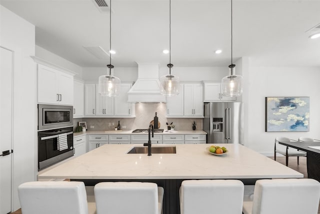 4623 Bridgewood Dr, Spring, TX 77386 - kitchen featuring appliances with stainless steel finishes, premium range hood, tasteful backsplash, a sink, and a kitchen breakfast bar