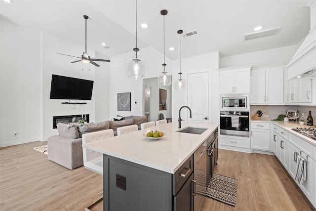 4623 Bridgewood Dr, Spring, TX 77386 - kitchen with appliances with stainless steel finishes, a sink, a kitchen bar, high vaulted ceiling, and light wood-style flooring