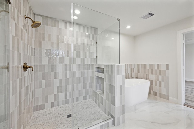 1935 Willow Rd, Wallis, TX 77485 - bathroom with a shower stall, a freestanding tub, recessed lighting, tile walls, and marble finish flooring