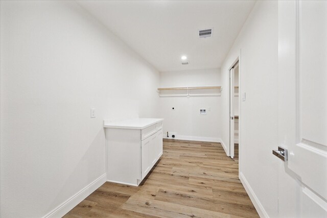 1935 Willow Rd, Wallis, TX 77485 - laundry area with washer hookup, visible vents, light wood-style flooring, and baseboards