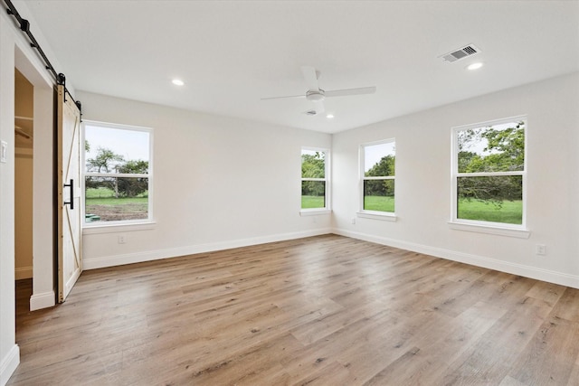 1935 Willow Rd, Wallis, TX 77485 - unfurnished bedroom featuring a barn door, multiple windows, baseboards, and recessed lighting