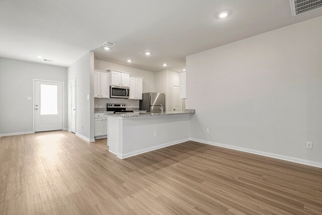 kitchen with light wood-type flooring, visible vents, white cabinetry, baseboards, and appliances with stainless steel finishes
