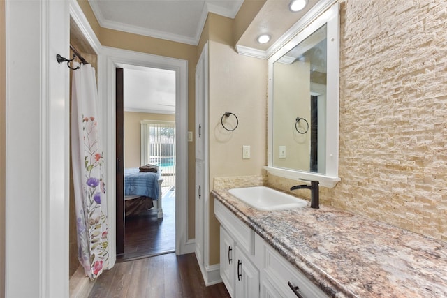 bathroom featuring vanity, ornamental molding, and wood finished floors