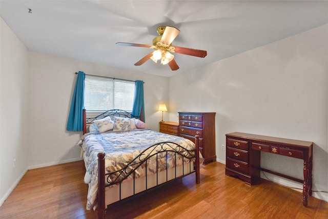 bedroom featuring baseboards, a ceiling fan, and wood finished floors