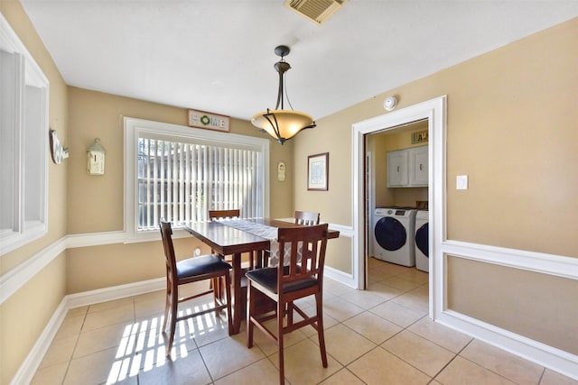 dining space with washing machine and clothes dryer, light tile patterned flooring, baseboards, and visible vents