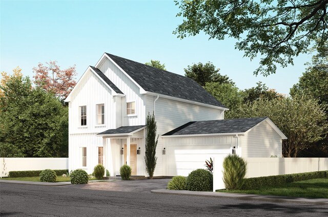 view of front facade featuring driveway, an attached garage, board and batten siding, and fence