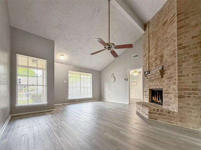 unfurnished living room featuring a ceiling fan, visible vents, wood finished floors, and baseboards