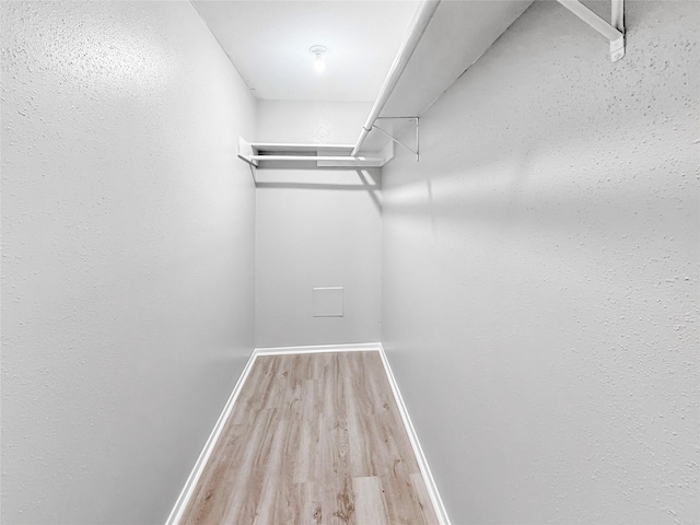 walk in closet with wood finished floors