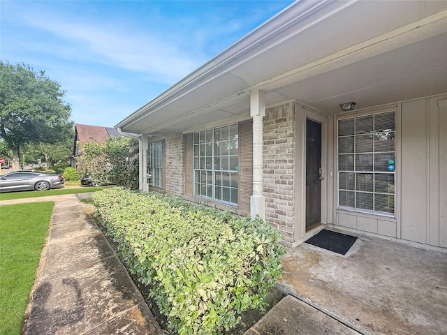 doorway to property featuring brick siding