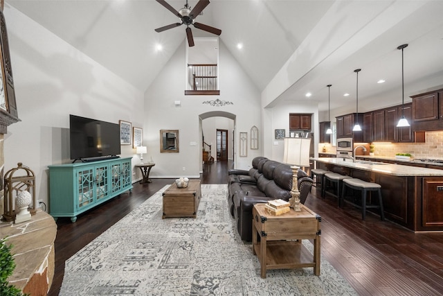 living room featuring recessed lighting, arched walkways, ceiling fan, dark wood-style floors, and high vaulted ceiling