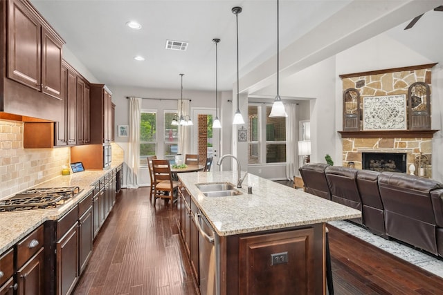 kitchen featuring light stone counters, a sink, visible vents, stainless steel appliances, and a chandelier
