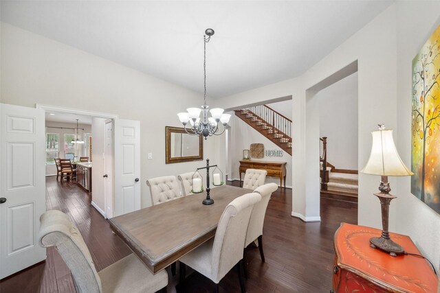 dining area featuring a notable chandelier, dark wood-style floors, and stairs