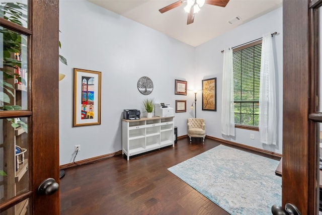 living area featuring baseboards, visible vents, ceiling fan, and dark wood finished floors