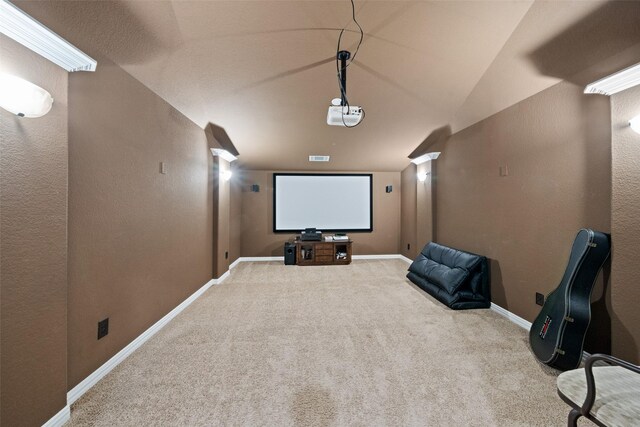 carpeted cinema room with lofted ceiling and baseboards