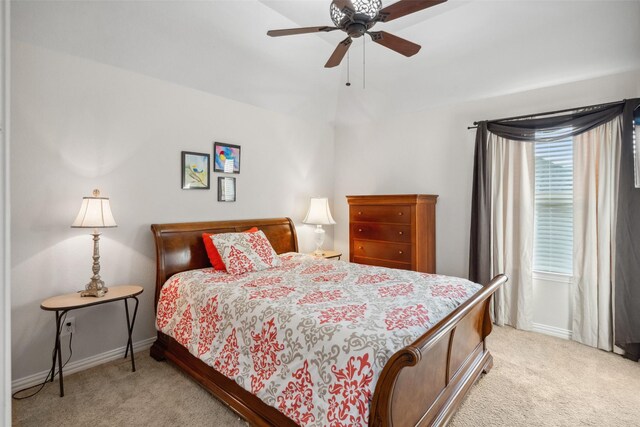 bedroom featuring light colored carpet, ceiling fan, and baseboards