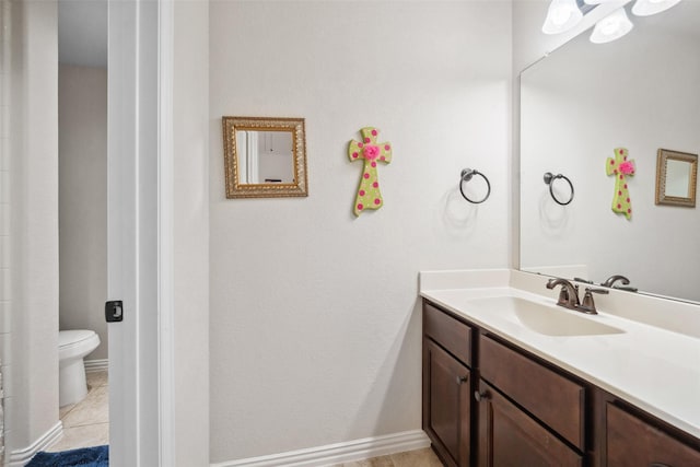 bathroom with baseboards, toilet, tile patterned flooring, and vanity