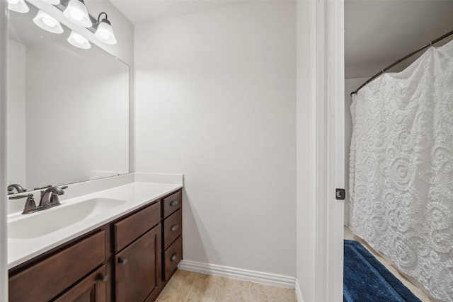 full bathroom with tile patterned floors, vanity, and baseboards