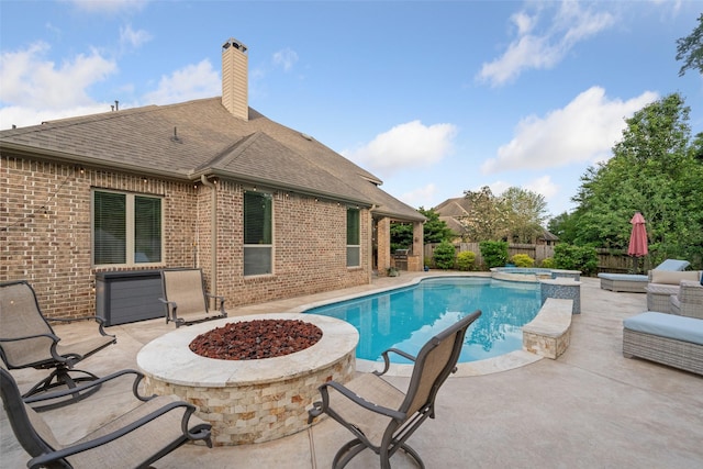 view of pool with a patio, an outdoor fire pit, a fenced backyard, and a pool with connected hot tub