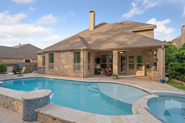 view of swimming pool featuring cooling unit, area for grilling, a patio area, fence, and a pool with connected hot tub