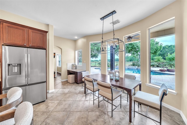 dining space with light tile patterned floors, baseboards, visible vents, and an inviting chandelier