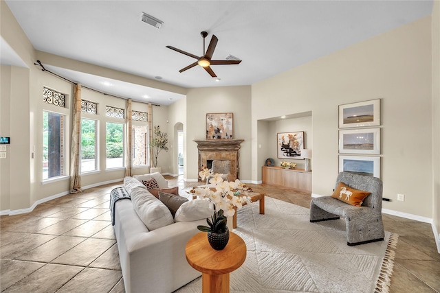living room with visible vents, ceiling fan, light tile patterned flooring, and a fireplace