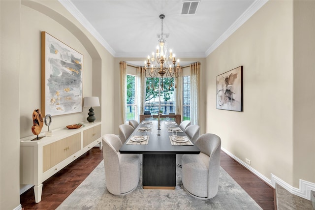 dining space featuring crown molding, dark wood-type flooring, and a chandelier