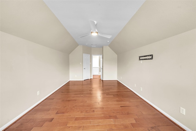 additional living space with light wood-style floors, baseboards, ceiling fan, and lofted ceiling