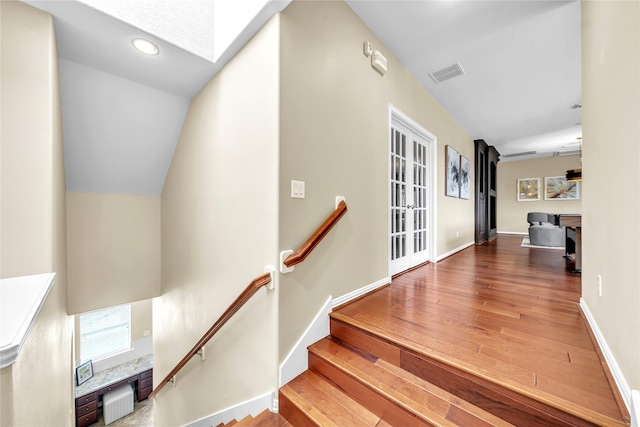 staircase with visible vents, hardwood / wood-style floors, baseboards, recessed lighting, and a skylight